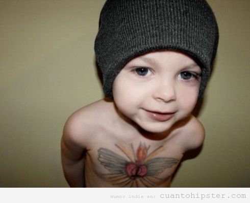 Niño hipster con gorro y mariposa tatuada en el pecho
