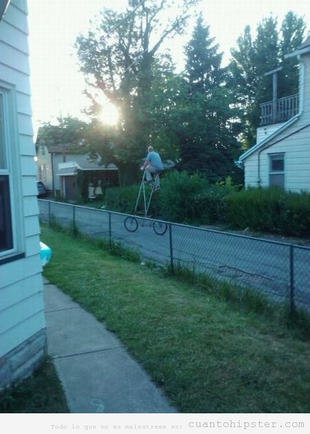 Bicicleta hipster muy alta dando paseo por el vecindario