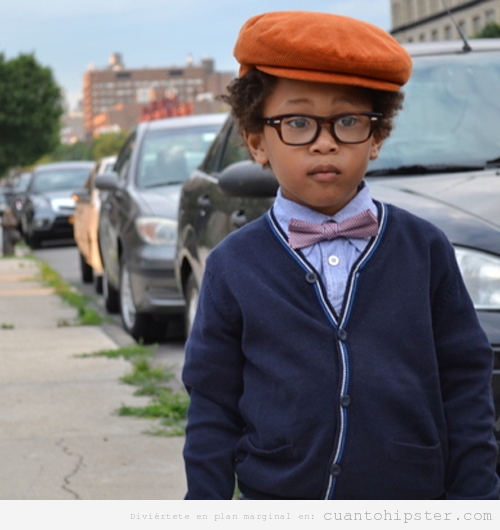 Niño con look hipster, boina, gafas de pasta, pajarita y cardigan