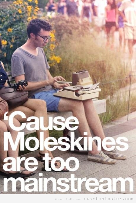 Chico hipster sentado en el parque con una máquina de escribir