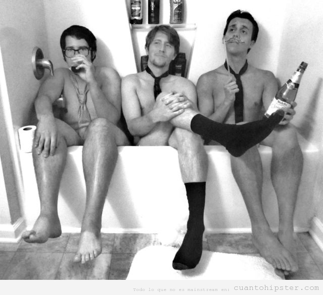 Tres chicos hipsters desnudos con corbata metidos en una bañera