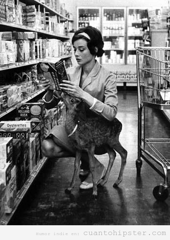 Foto antigua de una mujer con look vintage y un cervatillo en un supermercado