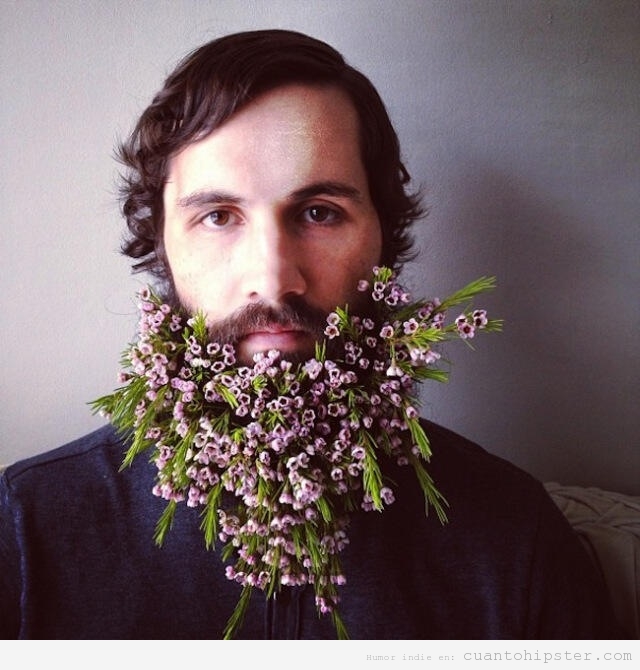 Hipster Hippie con flores enmarañadas en la barba larga