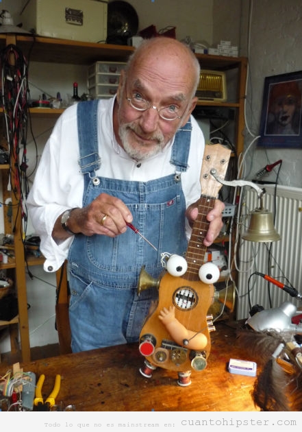 Foto curiosa de un hombre mayor tuneando un ukelele bizarro