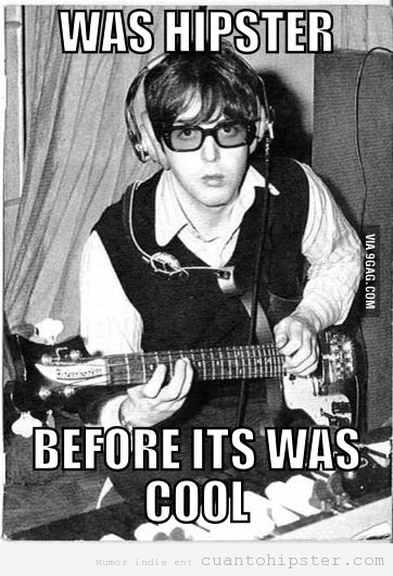 Paul McCartney de joven tocando la guitarra, con gafas y auriculares, estilo hipster