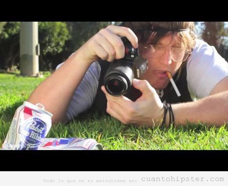 Imagen ridícula de un hipster haciendo una foto a latas de cerveza en la hierba