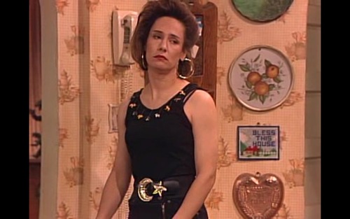 Hipster vestida como Jackie de Roseanne con cinturón dorado