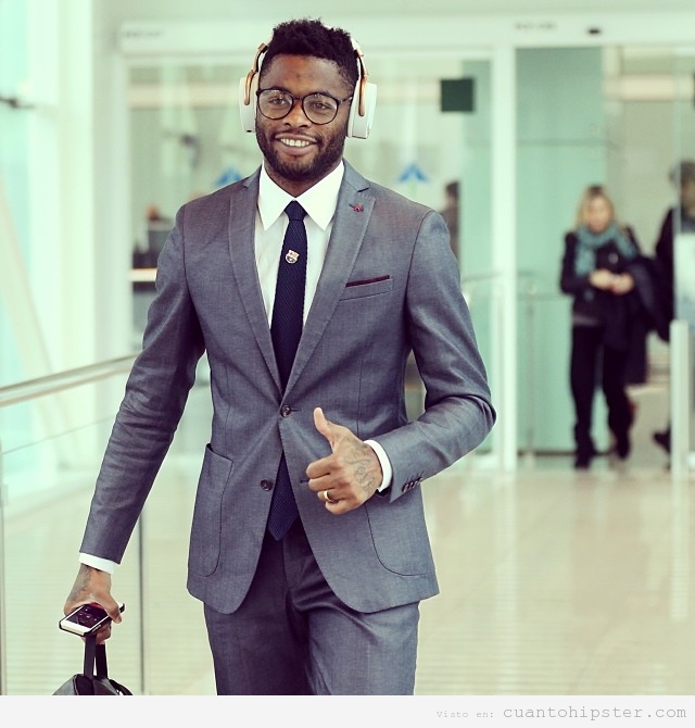 Alex Song con auriculares grandes hipsters