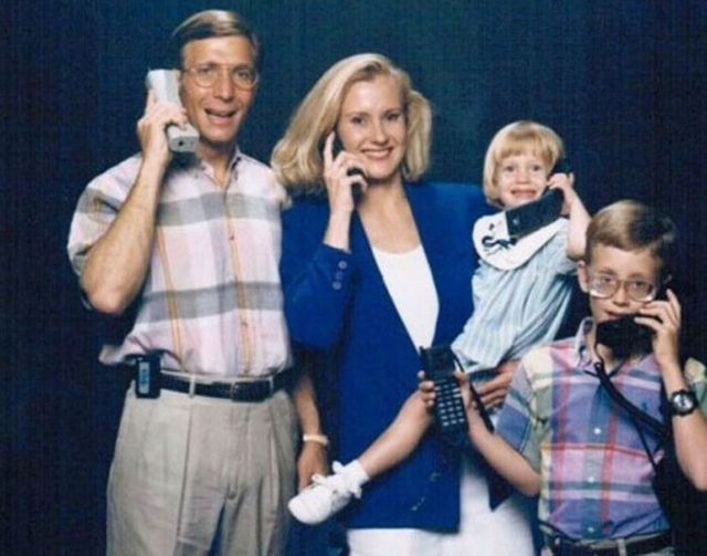 Foto familia moderna con teléfonos móviles años 90