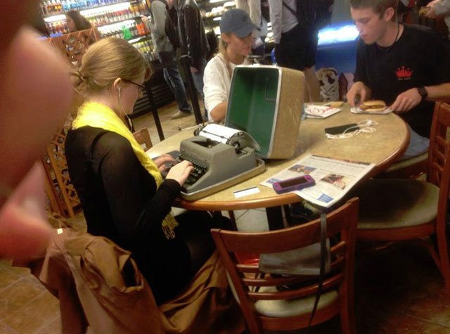 Hipster con máquina de escribir en la cafetería