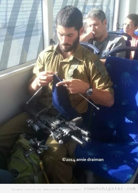 Soldado con barba hipster tejiendo en el autobus