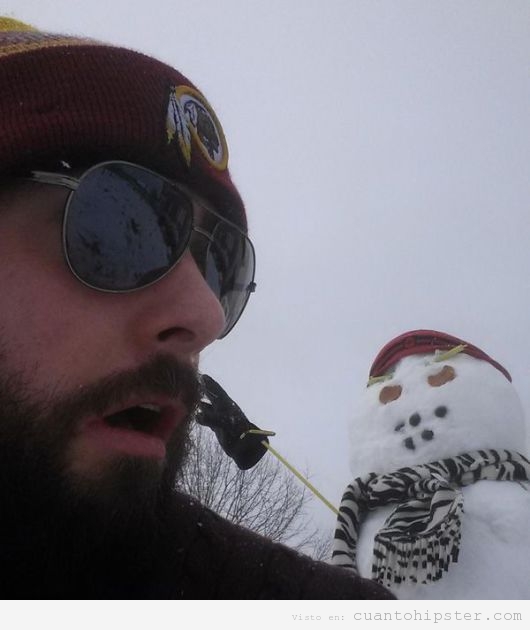 Foto hipster con un muñeco de nieve