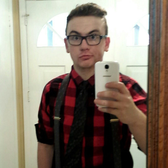 Selfie de un chico con look hipster con camisa cuadros y tirantes