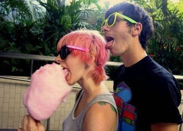 Foto graciosa pareja hipster comiendo algodón de azúcar
