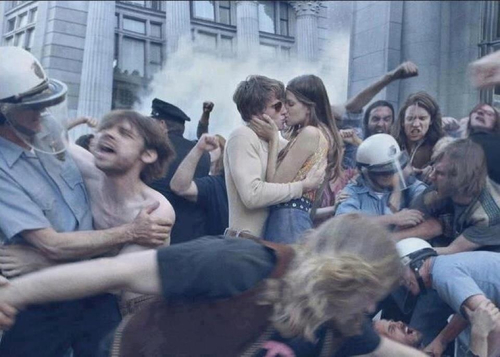 Foto antigua hippies besandose en una manifestación