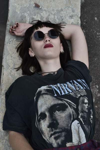 Moda new grunge. gafas de sol redondas y camiseta de Nirvana