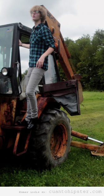 Retrato bucólico de un hipster en un tractor