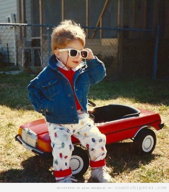Un hipster de niño con gafas de sol blancas y mucho estilo