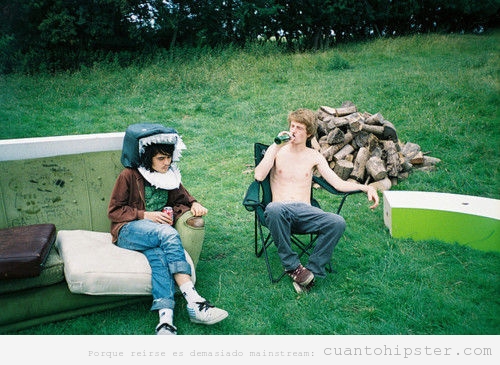 Hipsters  vagabundos  en un sofá en el campo con cabeza de tiburón 