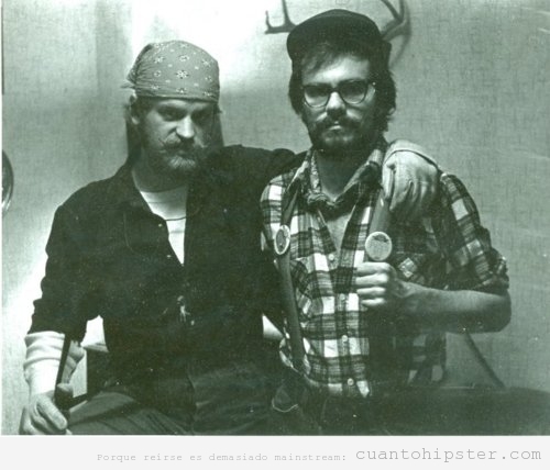 Foto antigua de Padre hipster con camisa de franela, tirantes, gorra de camionero y cuernos de ciervo