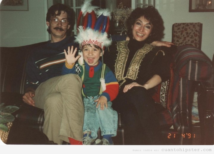 Niño disfrazado de indio con padres hipsters, foto retro, años 80