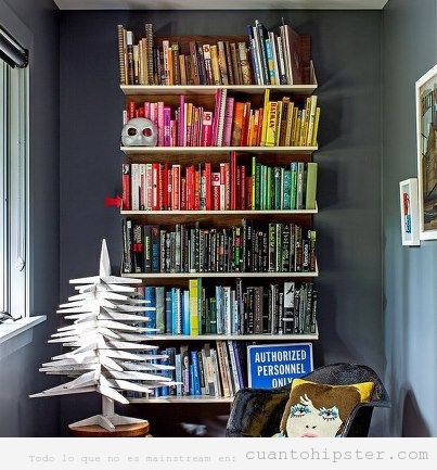 Estantería biblioteca con los libros organizados por colores