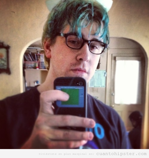 Imagen de un chico hipster con pelo azul, autofoto con game  boy