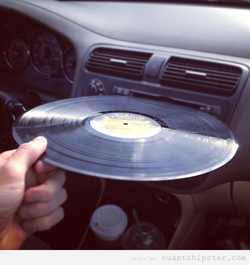 Foto graciosa, hipster intenta meter vinilo CD coche