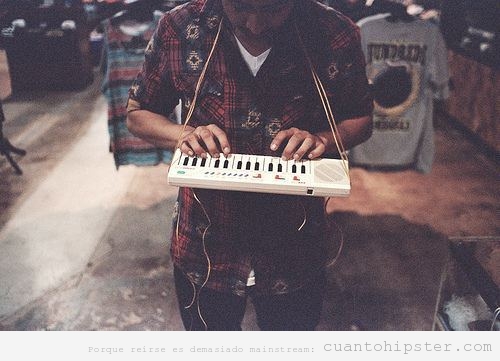 Foto hipster de un chico con un teclado casio colgado del cuello
