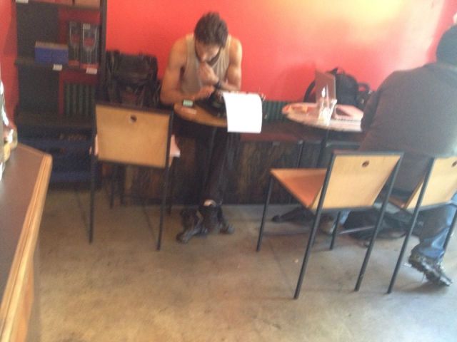 Foto de un hipster con máquina de escribir en una cafetería