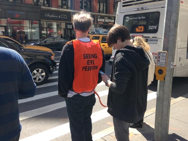 Hombre guía para personas que andan por la calle mirando el móvil