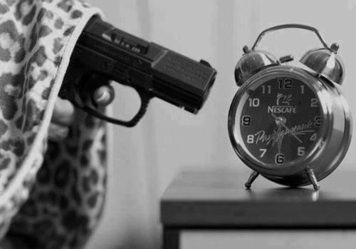 Foto graciosa, apagar despertador con un arma