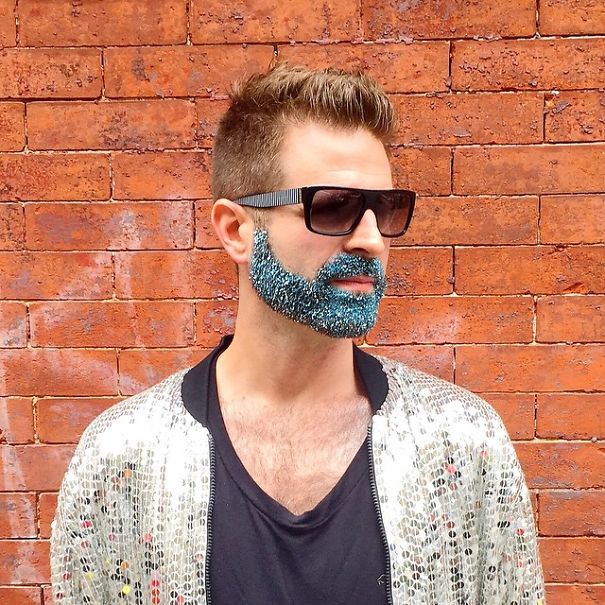 Foto de un chico hipster con la barba llena de purpurina