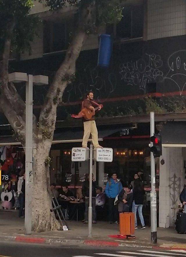 Foto guitarrista hipster subido señal tráfico