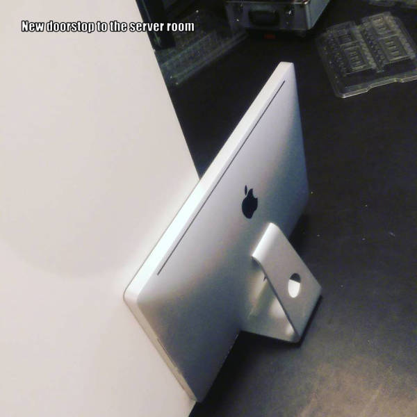 Foto graciosa ordenador Apple sujetando puerta